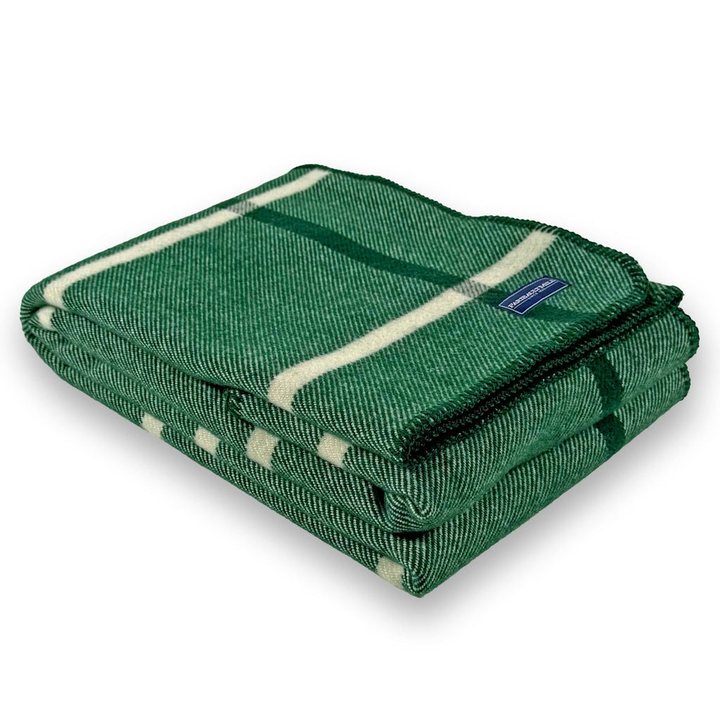 Folded forest green wool throw with a cream windowpane plaid