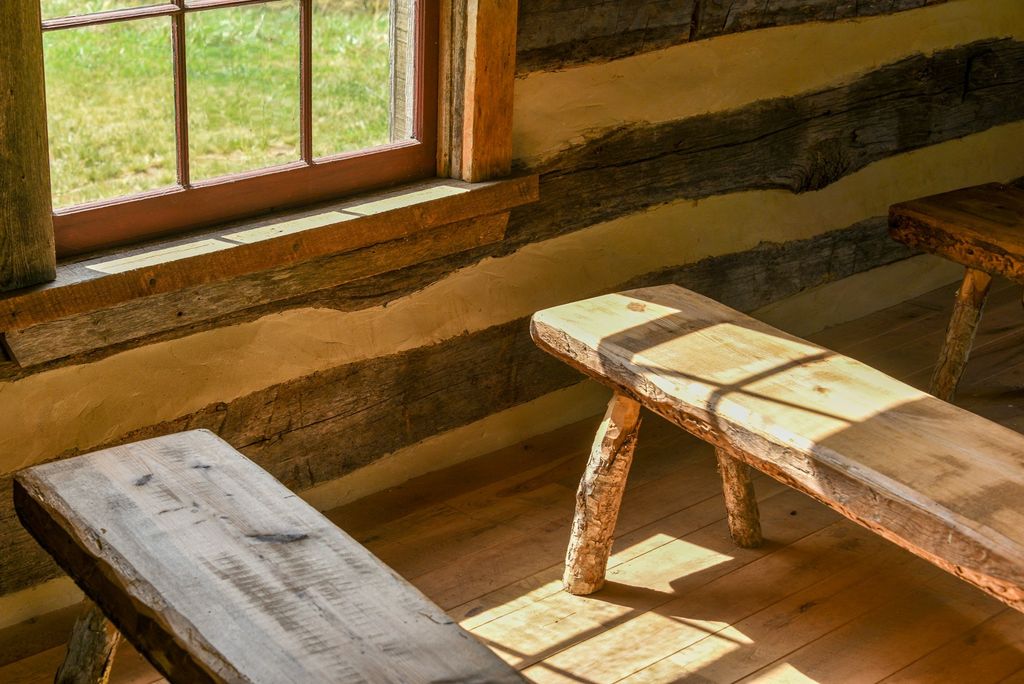 A wooden bench beneath a sunny window